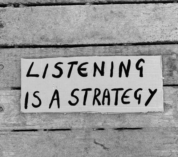 A sign that says Listening is a Strategy