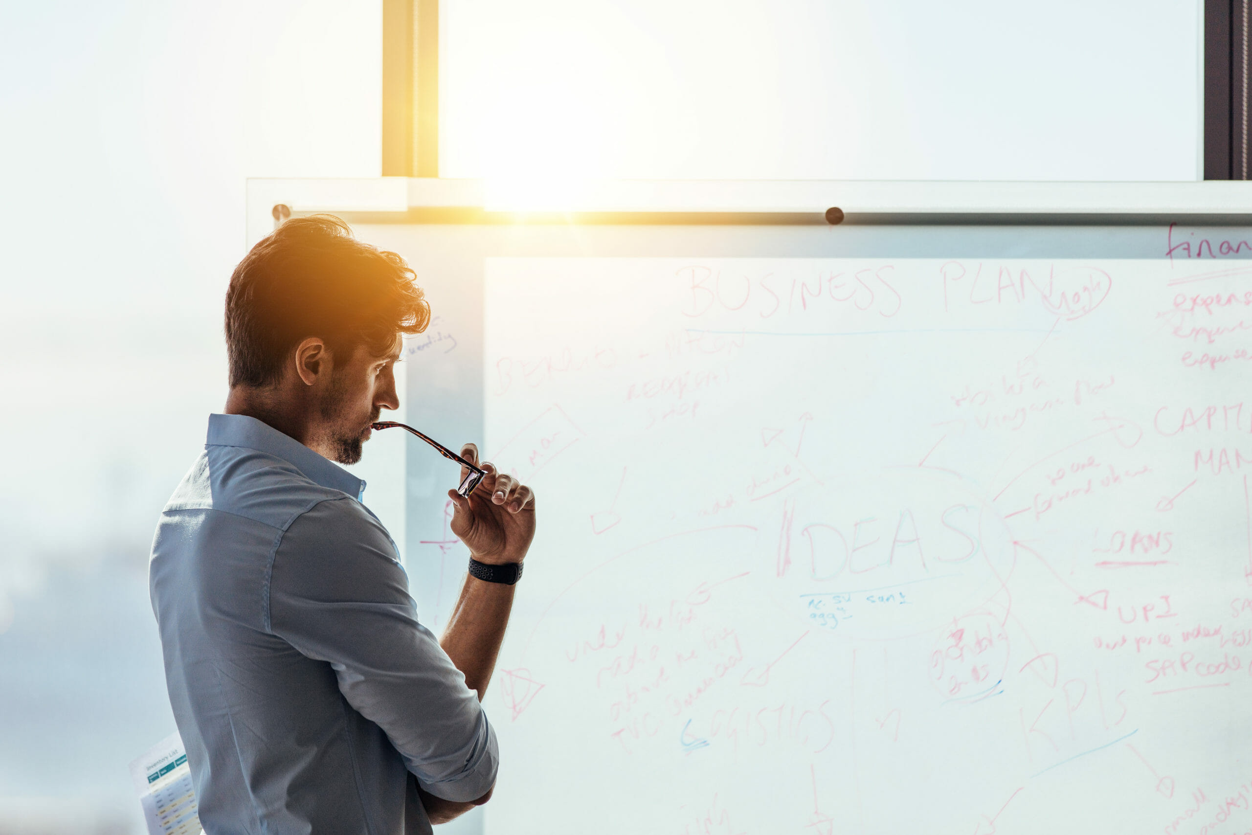 Man thinking while looking at a whiteboard shutterstock image